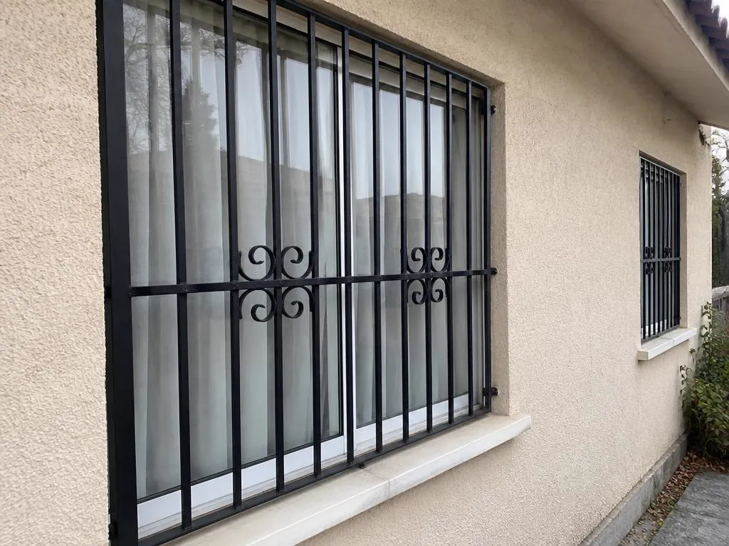 Rejas metálicas negras instaladas en las ventanas de una vivienda